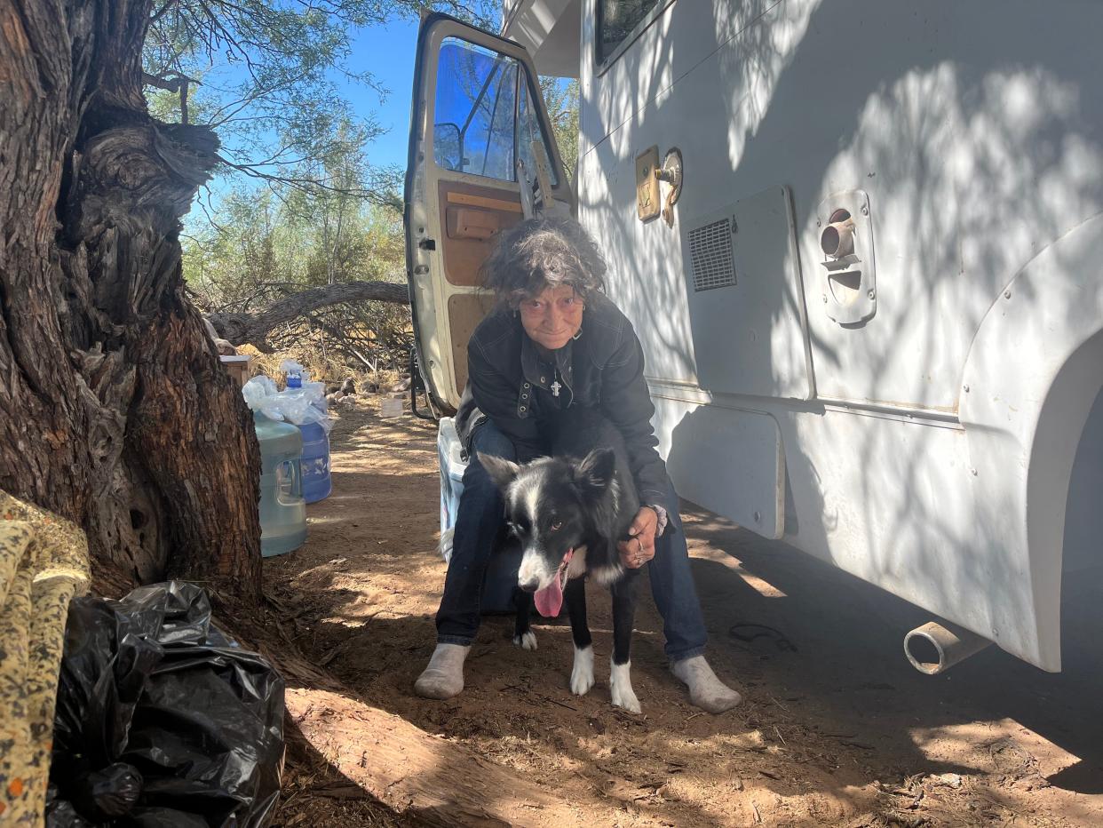 Rose Sherwood sits with her dog Nibbler at a campsite she and her partner have been living at near Goldfield Ghost Town on Oct. 3, 2023.