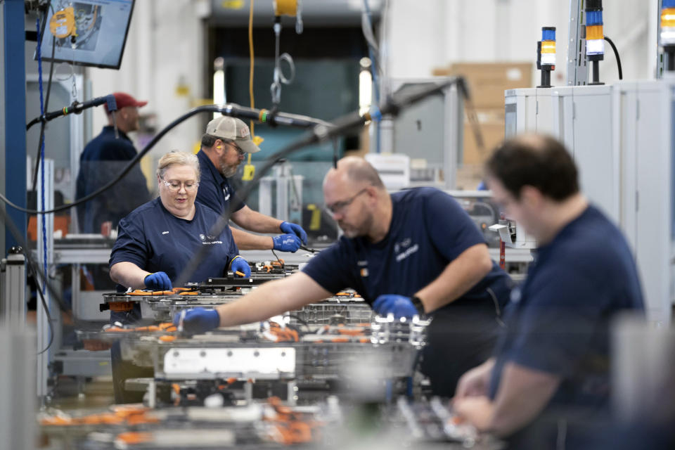 File - Employees work in the battery assembly hall at the BMW Spartanburg plant in Greer, S.C. Wednesday, Oct. 19, 2022. Employers have shrugged off rising interest rates, higher costs and fears of recession and just kept hiring. After creating a record 6.7 million jobs last year, they've been adding another 420,000 a month in 2022. (AP Photo/Sean Rayford, File)