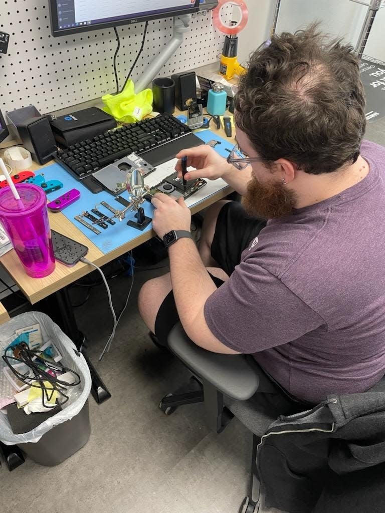 Evan Oelerich, a technician with Asurion Tech Repair & Solutions, fixes a variety of electronics at the Menomonee Falls location.