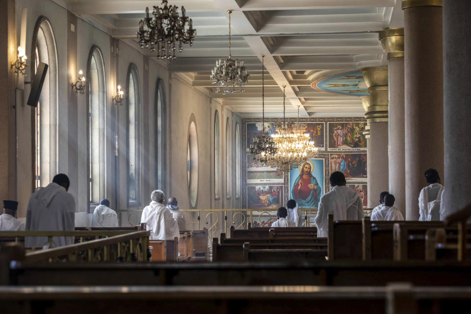 The congregation practices social distancing to curb the spread of the new coronavirus, as they sit a distance apart on pews and listen to a Sunday morning mass at the Bole Medhane Alem Ethiopian Orthodox Cathedral in Addis Ababa, Ethiopia Sunday, April 5, 2020. The new coronavirus causes mild or moderate symptoms for most people, but for some, especially older adults and people with existing health problems, it can cause more severe illness or death. (AP Photo/Mulugeta Ayene)