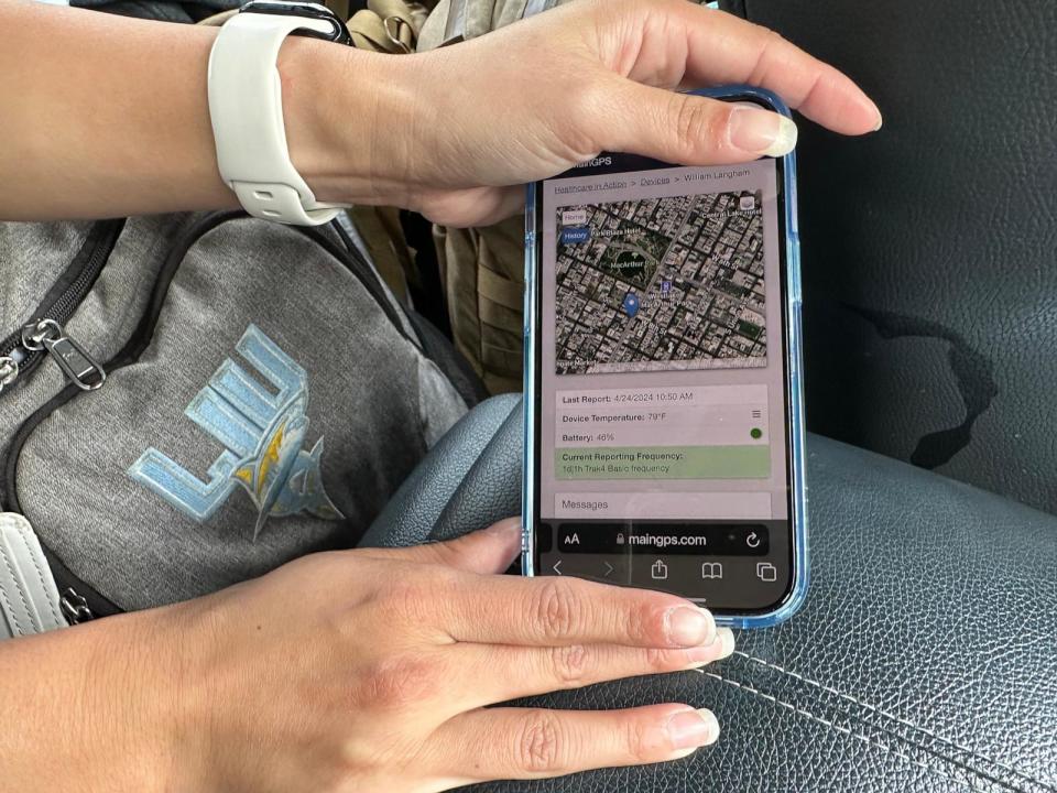 PHOTO: Isabelle Peng points on a phone to the location of a GPS tracking device attached to a homeless patient. Some homeless patients agree to wear the devices so providers can find them.  (Angela Hart/KFF Health News)