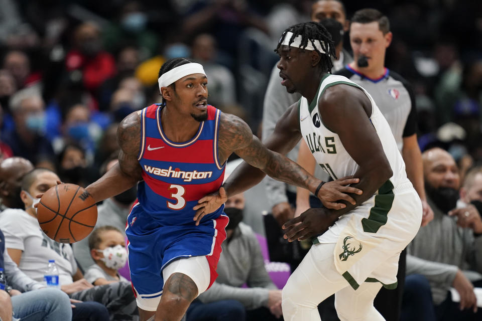 Washington Wizards guard Bradley Beal, left, drives past Milwaukee Bucks guard Jrue Holiday in the first half of an NBA basketball game, Sunday, Nov. 7, 2021, in Washington. (AP Photo/Patrick Semansky)