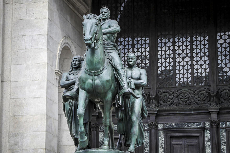 A bronze statue of Theodore Roosevelt on a horse with a Native American man on one side and an African man on the other side stands in front of the American Museum of Natural History on June 30, 2020 in New York. (Liao Pan / China News Service via Getty Images file)