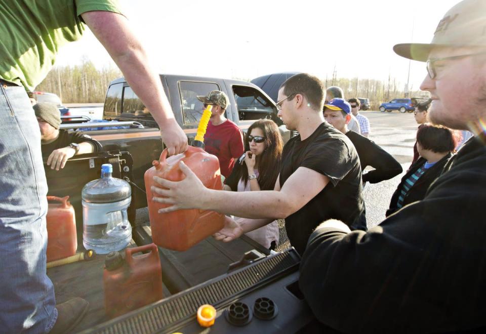  People gather for gas that is being handed out at a rest stop near Fort McMurray, Alta., on Wednesday, May 4, 2016. THE CANADIAN PRESS/Jason Franson