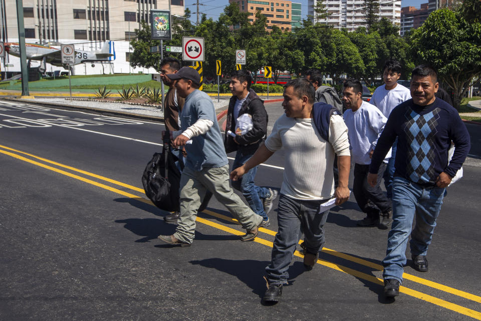 Guatemalan men who were deported from the United States cross a street after arriving in Guatemala City, Thursday, Nov. 21, 2019. Guatemala’s Foreign Ministry said a Honduran asylum seeker has also been returned by the United States to pursue asylum in Guatemala for the first time under an agreement signed in July. The Honduran man, who was not identified, had reached the U.S. border but was sent to Guatemala Thursday. (AP Photo/Moises Castillo)