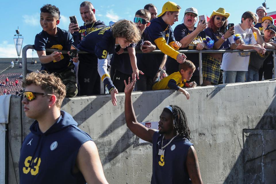 Michigan defensive back Rod Moore high-fives fans before the Alabama game at Rose Bowl Stadium in Pasadena, California. on Monday, Jan. 1, 2024.