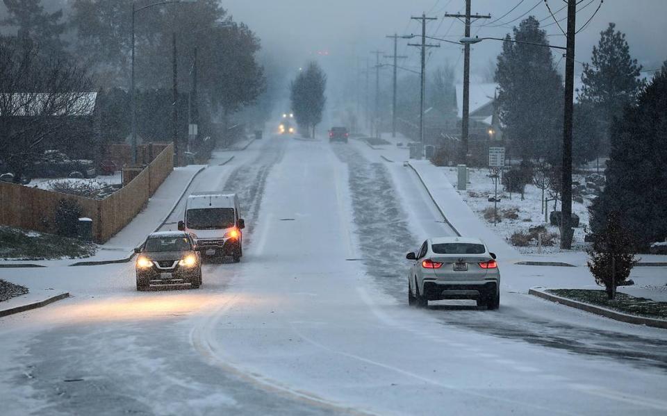 Early morning snowfall begins covering the roadway and ground as commuters travel on South Kellogg Street in Kennewick. Most Tri-City schools were expected to start on time and no delay of work at the Hanford nuclear site was announced.