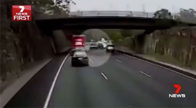 A black ute pulls into the right lane, into a small gap between two vehicles, then jerks back to the middle. Source: 7 News