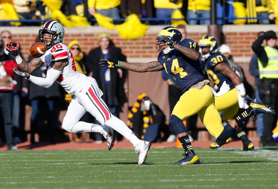 Ohio State Buckeyes wide receiver Chris Fields (80) catches a pass under pressure from Michigan Wolverines safety Josh Furman (14) in the second quarter of the college football game between the Ohio State Buckeyes and the Michigan Wolverines at Michigan Stadium in Ann Arbor, MI, Saturday afternoon, November 30, 2013. The Ohio State Buckeyes defeated the Michigan Wolverines 42 - 41. (The Columbus Dispatch / Eamon Queeney)