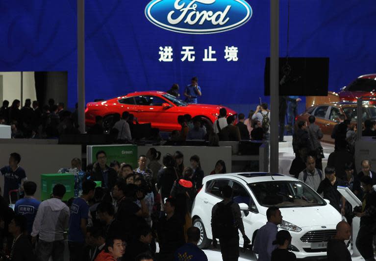 Visitors check out Ford cars on display at the Beijing International Automotive Exhibition on April 20, 2014