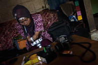 Armless professional photographer Rusidah, 44, carries out camera maintenance on March 13, 2012 in Purworejo, Indonesia. (Photo by Ulet Ifansasti/Getty Images)