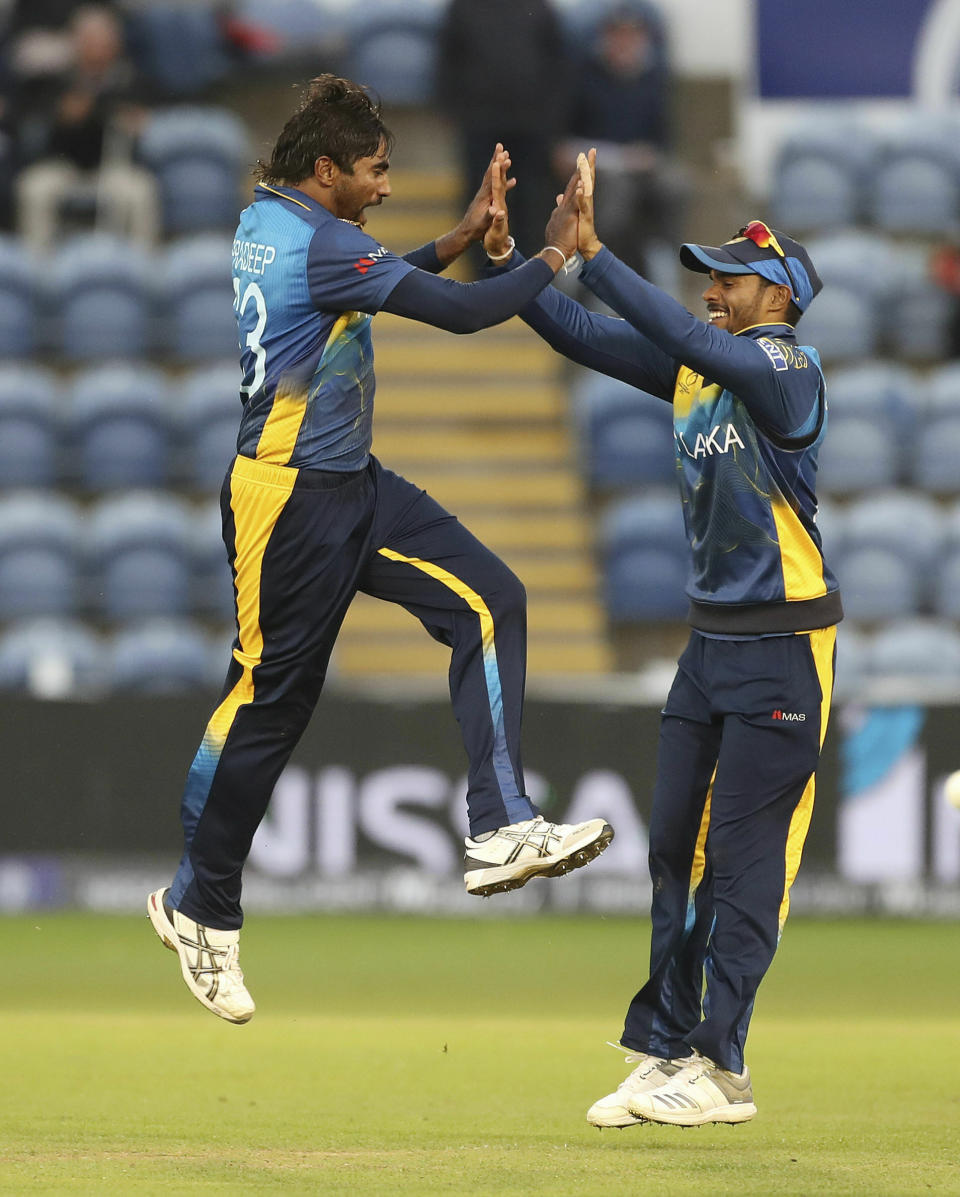 Sri Lanka's Nuwan Pradeep, left, celebrates with Dhananjaya de Silva taking the wicket of Afghanistan's Rashid Khan, during the Cricket World Cup group stage match between Sri Lanka and Afghanistan at the Cardiff Stadium, Wales, Tuesday June 4, 2019. (David Davies/PA via AP)