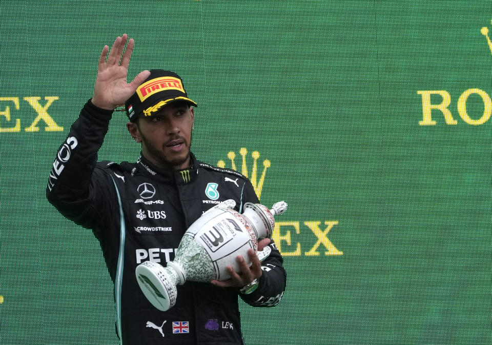 Mercedes driver Lewis Hamilton of Britain holds up his trophy on the podium after placing third after the Hungarian Formula One Grand Prix, at the Hungaroring racetrack in Mogyorod, Hungary, Sunday, Aug. 1, 2021. (AP Photo/Darko Bandic)