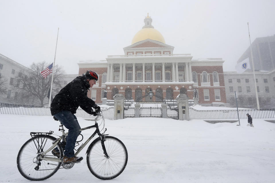 A man rides his bicycle past the State House during a blizzard in Boston, Massachusetts January 27, 2015. A blizzard swept across the northeastern United States on Tuesday, dropping more than a foot (30 cm) of snow across Massachusetts and Connecticut. REUTERS/Dominick Reuter  (UNITED STATES - Tags: ENVIRONMENT)