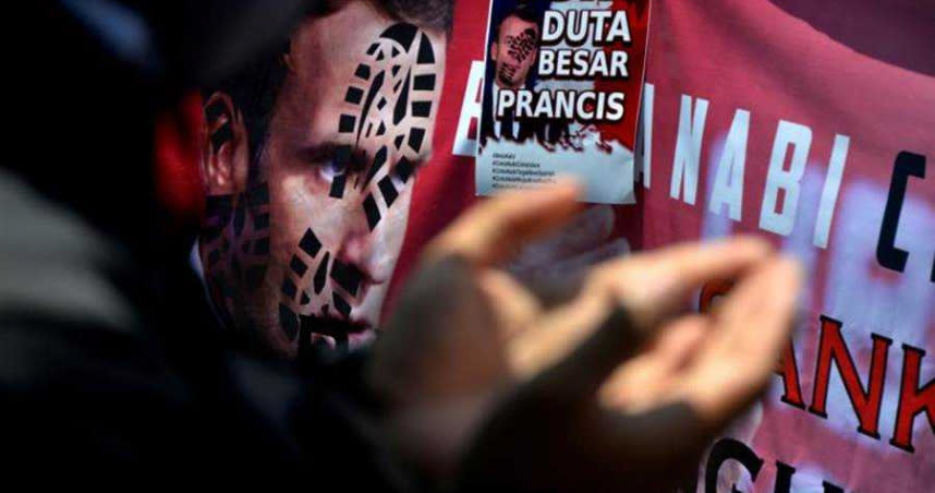 印尼的穆斯林示威活動中，有人在馬克洪畫像的臉上加上鞋印，這是伊斯蘭教中嚴重侮辱的表示。（圖／達志／路透社）