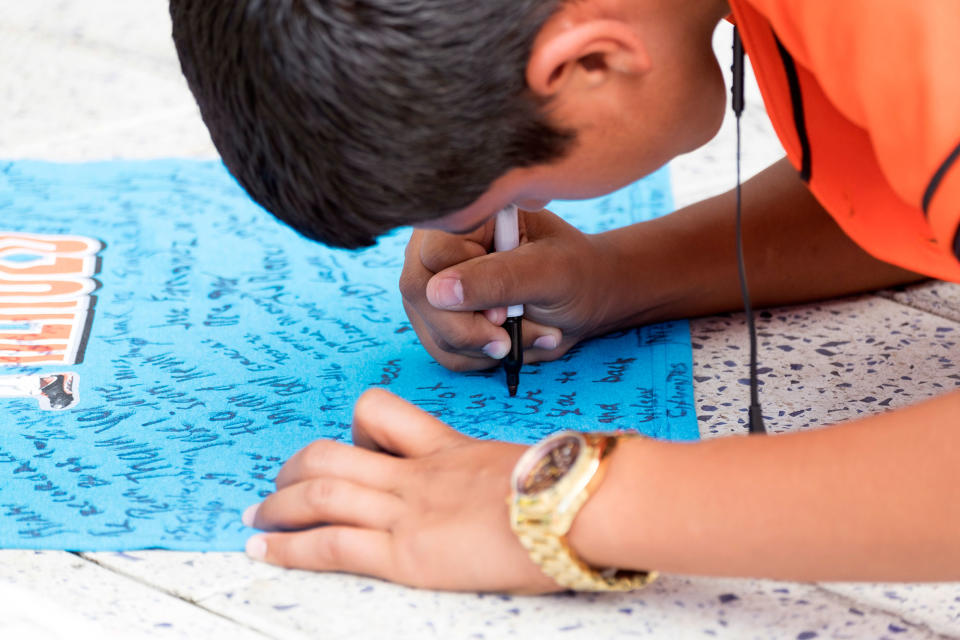 <p>Luis Ruiz, 14, signs a remembrance shirt at a makeshift memorial in honor of Jose Fernandez sits outside Marlins Park, Sunday, Sept. 25, 2016. Jose Fernandez, the ace right-hander for the Miami Marlins who escaped Cuba to become one of baseball’s brightest stars, was killed in a boating accident early Sunday morning. Fernandez was 24. (AP Photo/Gaston De Cardenas) </p>