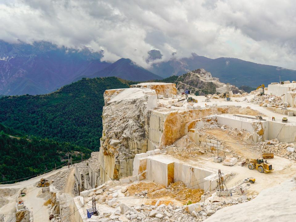 A wide view of a marble mountain range dotted with quarries
