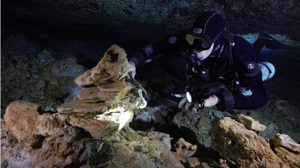 A diver examines a landmark of piled stones left in the oldest ochre mine ever found in
the Americas, used 10,000 to 12,000 years ago by the earliest inhabitants of the Western
Hemisphere to procure the ancient commodity.