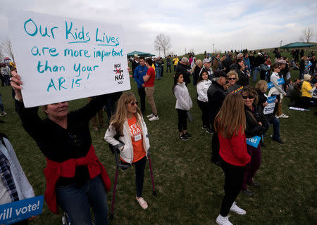 A woman holds a sign as teens kick off a voter registration rally, a day ahead of the 19th anniversary of the massacre at Columbine High School, in Littleton, Colorado, U.S., April 19, 2018. REUTERS/Rick Wilking