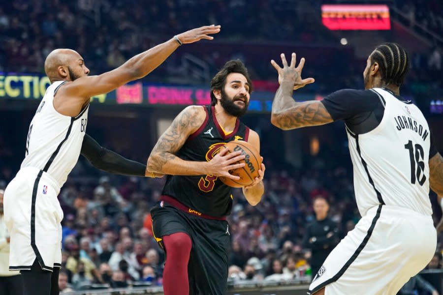 Cleveland Cavaliers’ Ricky Rubio, center, drives between Brooklyn Nets’ Jevon Carter, left, and James Johnson during the first half of an NBA basketball game Monday, Nov. 22, 2021, in Cleveland. (AP Photo/Tony Dejak)