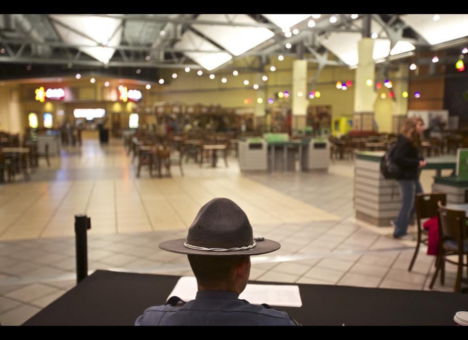 A security guard looks over the food court at the Clackamas Town Center mall as it opens, on Friday, Dec 14, 2012 in Portland, Ore. The mall is reopening, three days after a gunman killed two people and wounded a third amid a holiday shopping crowd estimated at 10,000. The shooter, Jacob Tyler Roberts, killed himself after the attack Tuesday afternoon.