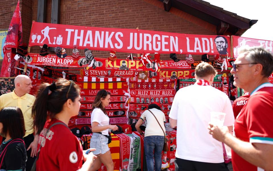 Merchandise is seen for sale outside the stadium with a banner reading "Jurgen Klopp Liverpool Legend" prior to the Premier League match between Liverpool FC and Wolverhampton Wanderers at Anfield on May 19, 2024 in Liverpool, England