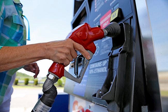 A woman holds a nozzle as she refuels her car on July 16, 2015, at a Costco gas station in Robinson Township, Pa. Prices for coal, natural gas, oil and the fuels made from crude such as gasoline and diesel are all far less expensive than they have been in recent years, delivering big breaks for consumers and decimating energy company profits and leading to huge layoffs.