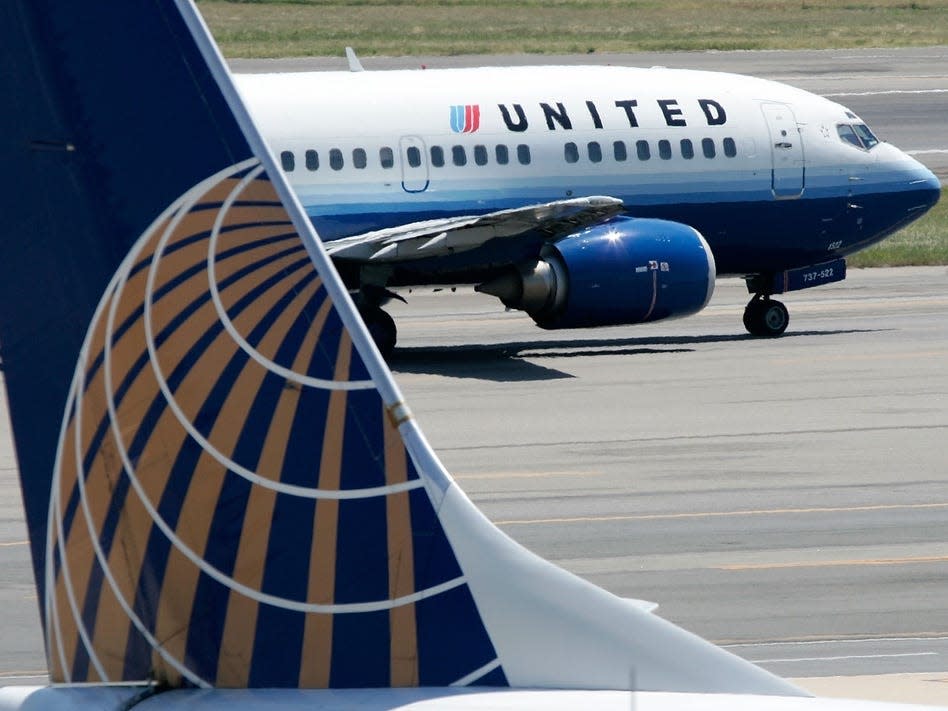 A United Airlines aircraft passes by a Continental Airlines aircraft as it taxis to takeoff from the runway of Ronald Reagan National Airport August 16, 2006 in Washington, DC.