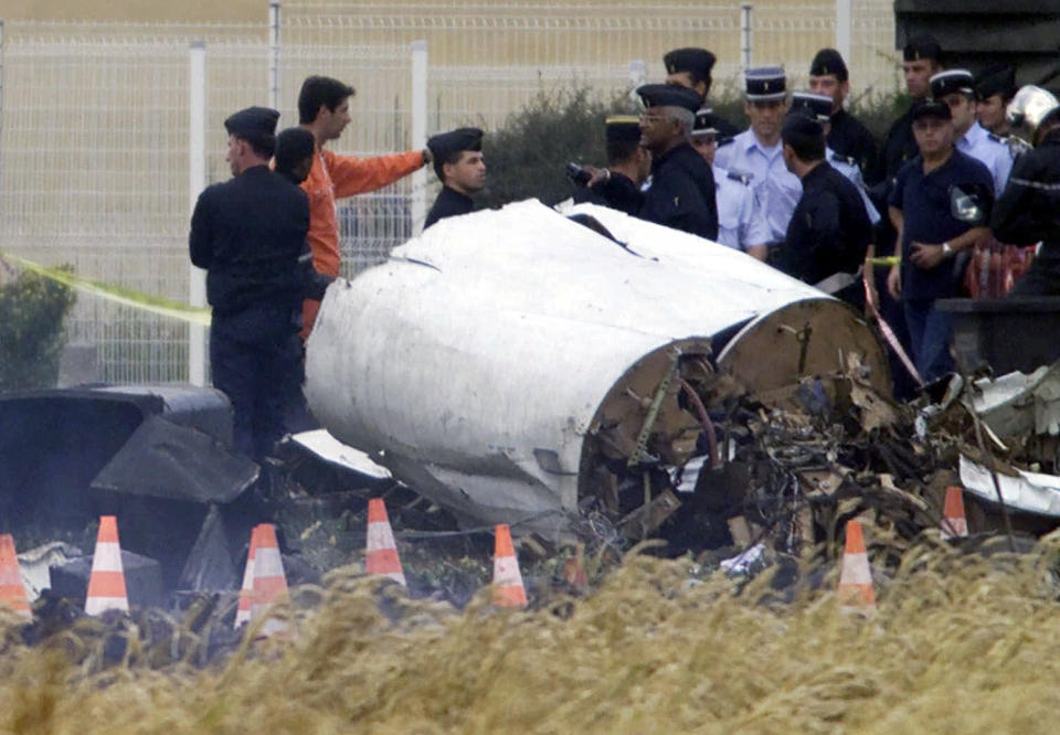 FILE - In this July 25, 2000, file photo, rescue workers stand on the crash site of an Air France Concorde plane that crashed in Gonesse, outside Paris, shortly after take off. A French appeals court is expected to decide on Thursday, Nov. 29, 2012, whether to uphold a manslaughter conviction against Continental Airlines for the crash over a decade ago of an Air France Concorde that killed 113 people. Continental Airlines, Inc. and one of its mechanics were convicted in 2010. (AP Photo/Michel Euler, File)