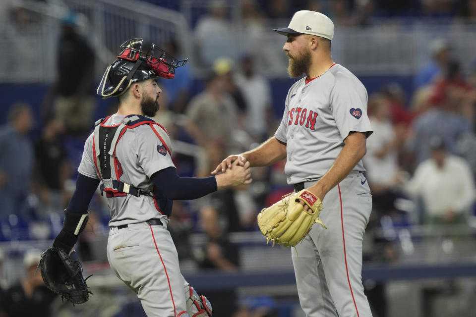 Boston Red Sox relief pitcher Greg Weissert, right, and catcher Reese McGuire, left, shake hands at the end of a baseball game against the Miami Marlins, Thursday, July 4, 2024, in Miami. (AP Photo/Marta Lavandier)