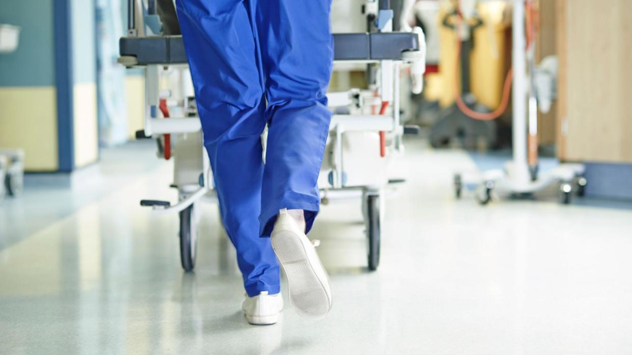 Surgeon walking a hospital bed down a corridor