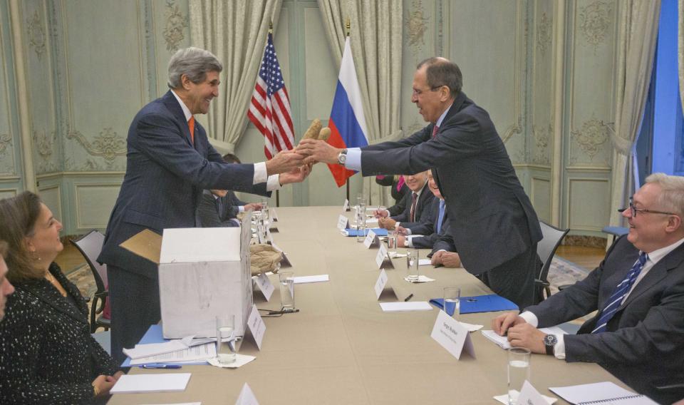 U.S. Secretary of State John Kerry, standing left, gives a pair of Idaho potatoes as a gift for Russia's Foreign Minister Sergey Lavrov at the start of their meeting at the U.S. Ambassador's residence in Paris, France, Monday, Jan. 13, 2014. Kerry is in Paris on a two-day meeting on Syria to rally international support for ending the three-year civil war in Syria. (AP Photo/Pablo Martinez Monsivais, Pool)