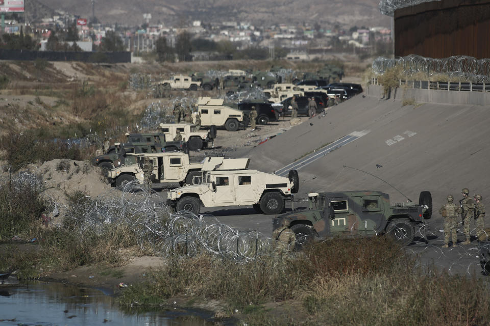 Guardias militares estadounidenses en la frontera de El Paso con México, vistos desde Ciudad Juárez, México, el martes 20 de diciembre de 2022. Migrantes en la frontera de México con Estados Unidos buscaban cobijo del frío mientras las restricciones que impidieron que mucha gente pidiera asilo en Estados Unidos se mantienen más allá de la fecha prevista. La decisión judicial sobre si se retiran las restricciones podría ser repentina, lo que ha acumulado la presión en las comunidades de ambos lados de la frontera. (AP Foto/Christian Chavez)