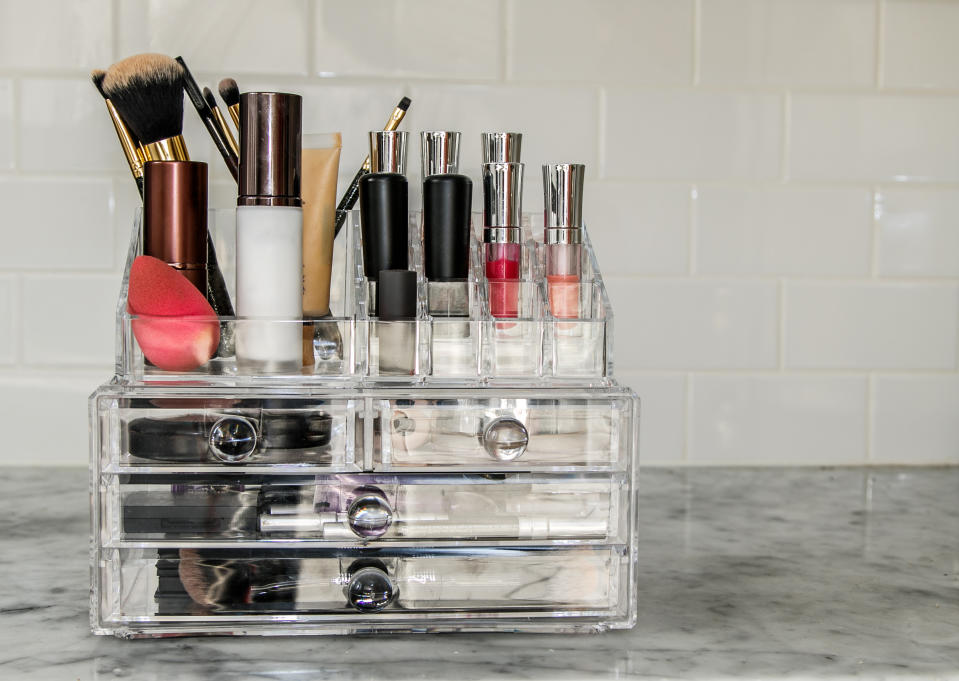 Transparent makeup organizer with numerous items.