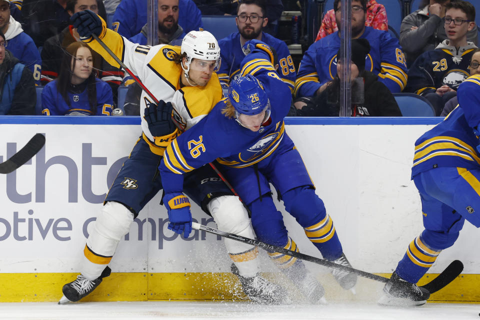 Nashville Predators left wing Egor Afanasyev (70) and Buffalo Sabres defenseman Rasmus Dahlin (26) battle for the puck during the second period of an NHL hockey game, Tuesday, March 21, 2023, in Buffalo, N.Y. (AP Photo/Jeffrey T. Barnes)