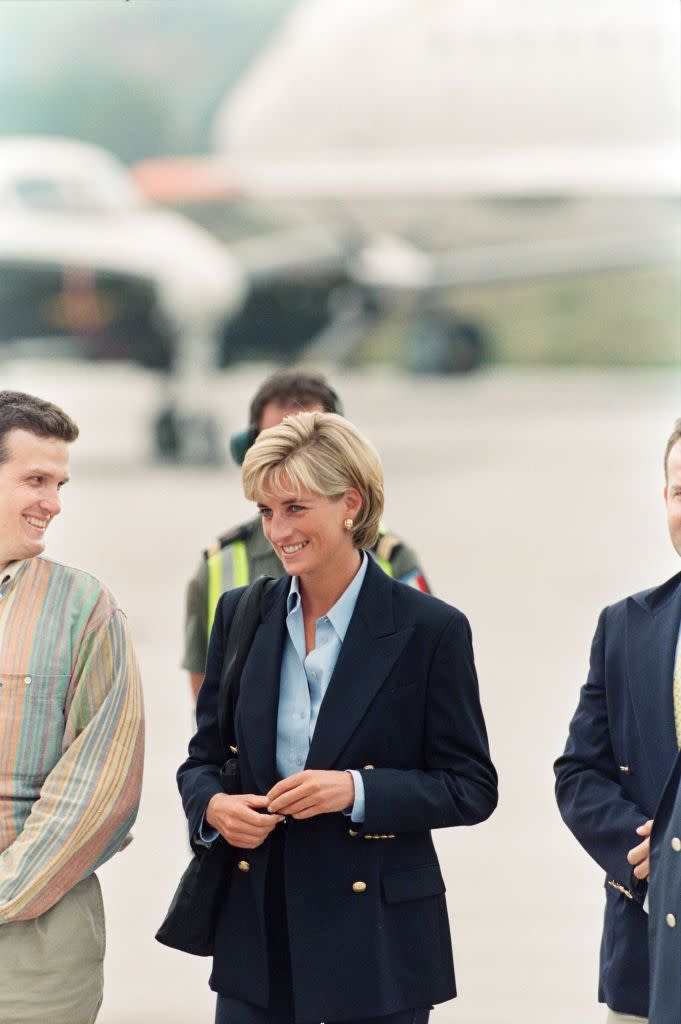 <p>In August 1997, Diana wore a classic navy blazer with statement gold buttons while arriving at Sarajevo airport on a trip to raise awareness on land mines.</p>