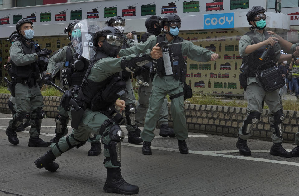 Riot police use pepper spray on protesters during a demonstration against Beijing's national security legislation in Causeway Bay in Hong Kong, Sunday, May 24, 2020. Hong Kong police fired volleys of tear gas in a popular shopping district as hundreds took to the streets Sunday to march against China's proposed tough national security legislation for the city. (AP Photo/Vincent Yu)