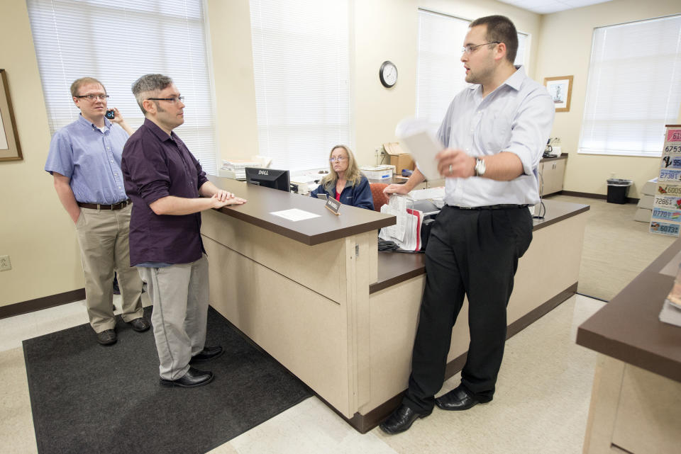 David Ermold (left) and his husband, David Moore (center), were among the couples who were denied marriage licenses by Kim Davis in 2015. (Photo: Lexington Herald-Leader via Getty Images)