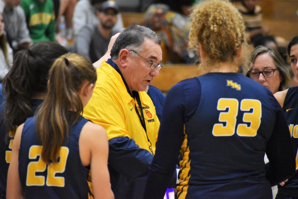 Mooresville players huddle around as coach Mark Hurt corrects the team while in a timeout during the Pioneers' matchup with Cathedral on Jan. 1, 2023.