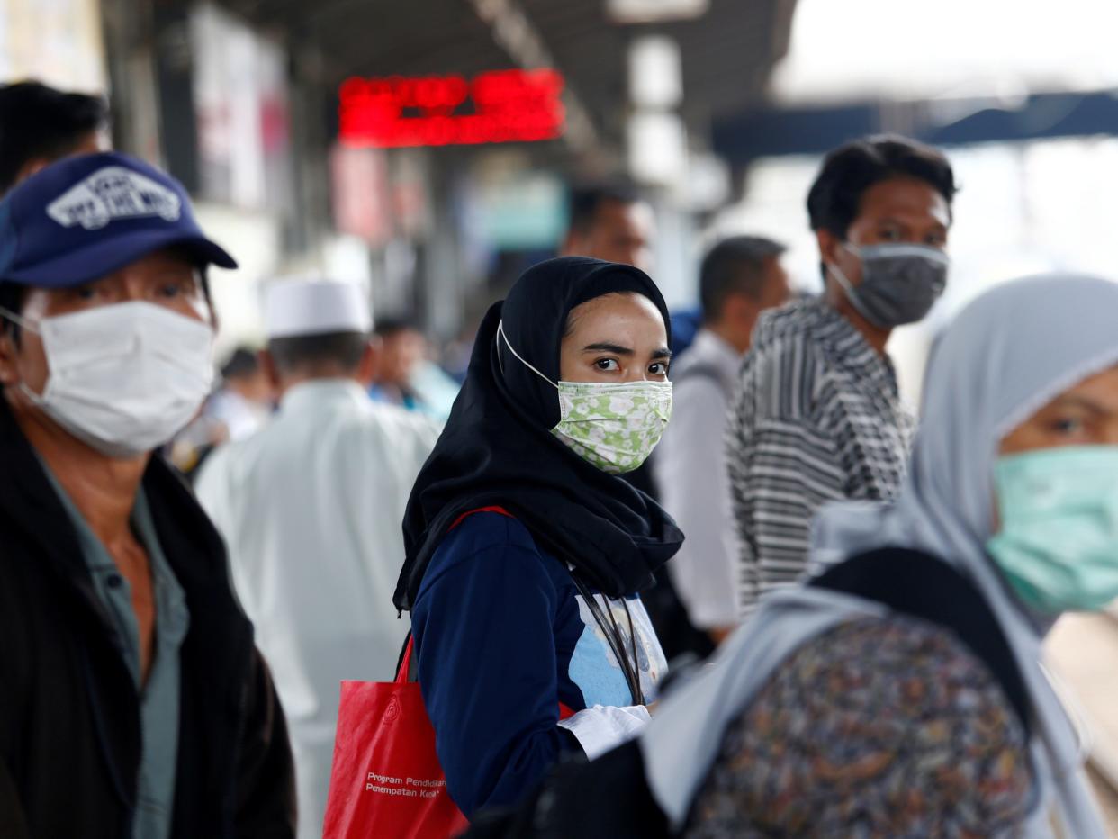 FILE PHOTO: People with surgical masks look on at station Tanah Abang, following the outbreak of the coronavirus in China, in Jakarta, Indonesia February 13, 2020. REUTERS/Ajeng Dinar Ulfiana/File Photo