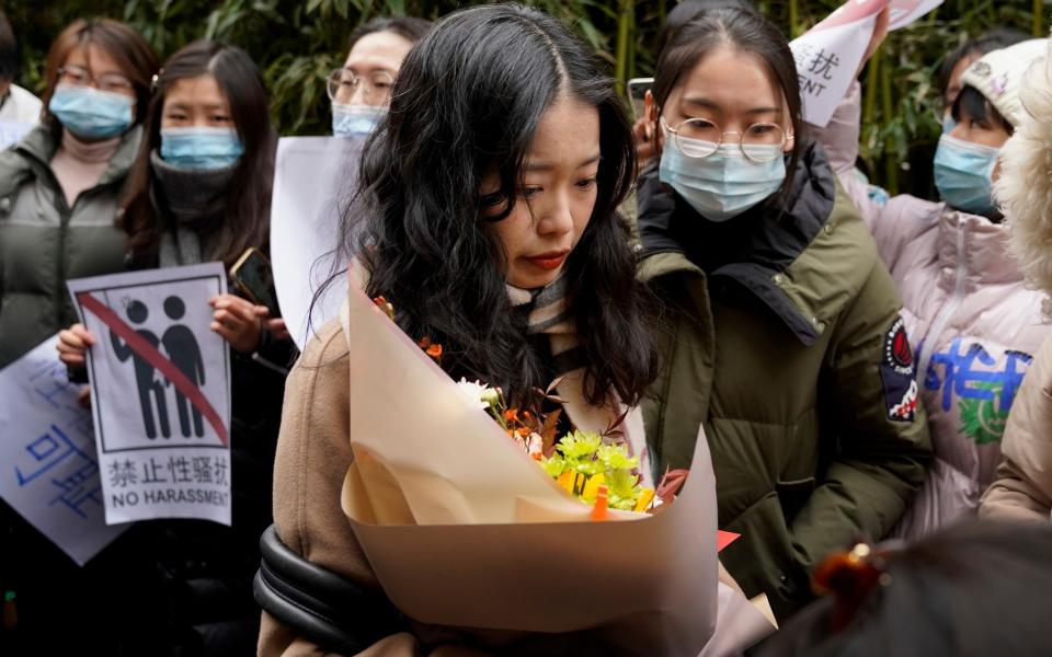 Zhou Xiaoxuan, center, walks by her supporters upon arrival at a courthouse in Beijing - Andy Wong/Ap