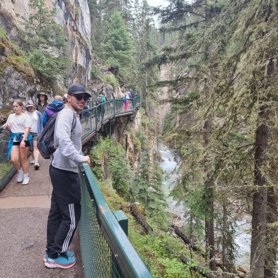 Author Shay in Johnston Canyon, a hiking path overlooking trees and water