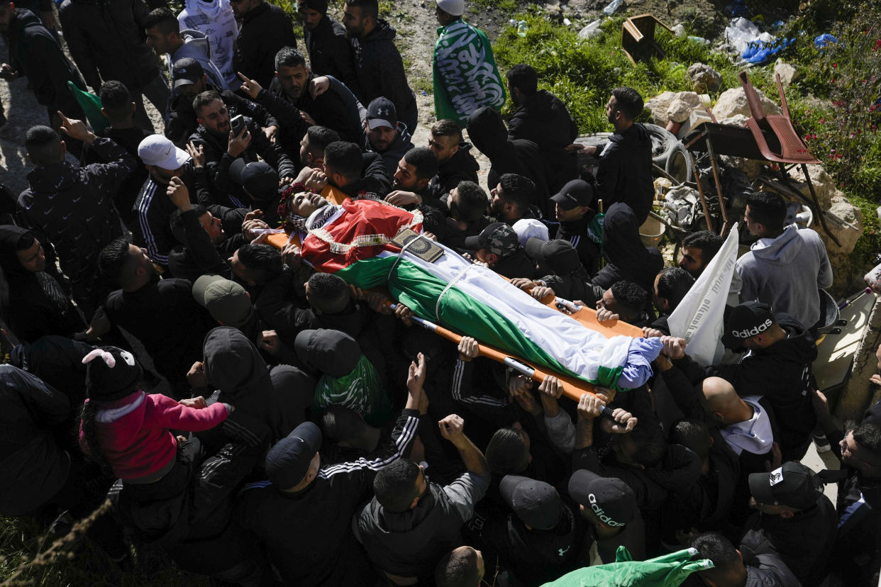 Palestinian mourners carry the body of Yusef Muhaisen during his funeral in the West Bank town of al Ram, north of Jerusalem, Friday, Jan. 27, 2023. Muhaisen, 22, was killed during clashes with Israeli troops. (AP Photo/Majdi Mohammed)