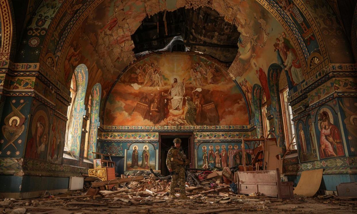 <span>Ukrainian serviceman Gennadiy Yudin stands inside orthodox church heavily damaged by a Russian bombing in Novoekonomichne, Ukraine.</span><span>Photograph: Evgeniy Maloletka/AP</span>