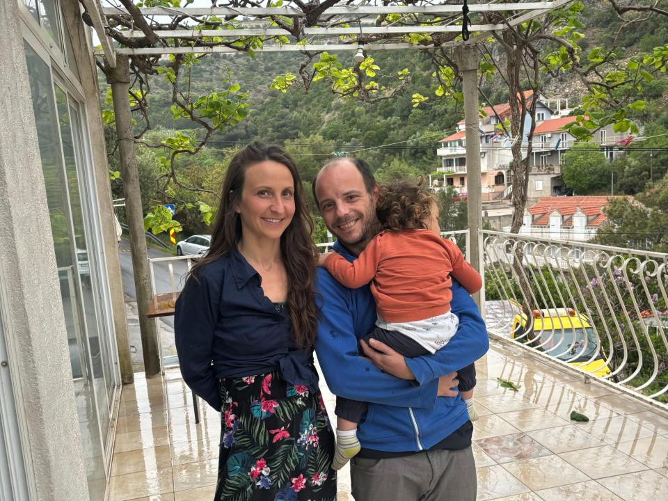 Diana Marlais, Bogdan Nicolae Dascalescu, and their child on the balcony of their apartment.