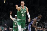 Boston Celtics' Kristaps Porzingis (8) celebrates his 3-pointer, next to Sacramento Kings' Harrison Barnes (40) during the first half of an NBA basketball game Friday, April 5, 2024, in Boston. (AP Photo/Michael Dwyer)