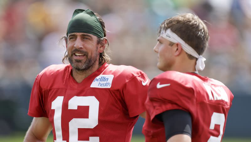 Green Bay Packers quarterback Aaron Rodgers (12) and New York Jets quarterback Zach Wilson (2) talk during a joint NFL football training camp practice Wednesday, Aug. 18, 2021, in Green Bay, Wis. Rodgers and Wilson are now teammates after the Packers traded Rodgers to the Jets.