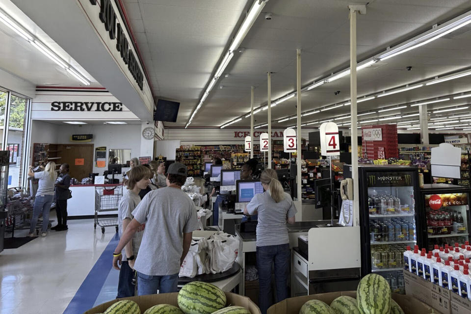 Employees work the checkout lines of the Mad Butcher grocery store in Fordyce, Arkansas on Tuesday, July 2, 2024. The grocery store reopened on Tuesday, 11 days after a shooter killed four people and injured 10 others in in the store and its parking lot. (AP Photo/Andrew DeMillo)