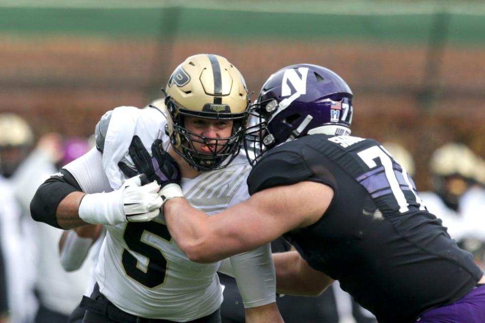 Northwestern offensive lineman Ben Wrather (71) blocks Purdue defensive end George Karlaftis (5) during the first quarter of an NCAA college football game, Saturday, Nov. 20, 2021 at Wrigley Field in Chicago.