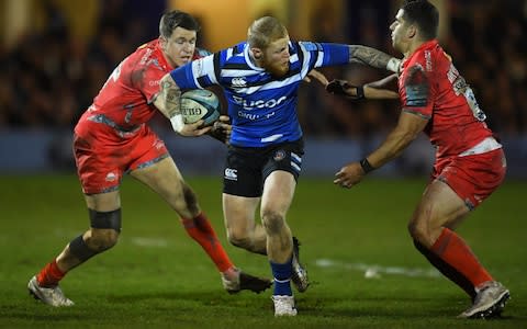 Tom Homer of Bath Rugby looks to break past the tackle from Sam James of Sale Sharks and Rohan Janse van Rensburg of Sale Sharks during the Gallagher Premiership Rugby match between Bath Rugby and Sale Sharks at The Recreation Ground on December 28, 2019 in Bath, England - Credit: Getty Images